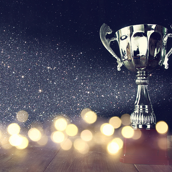 silver trophy on dark sparkly background with bokeh